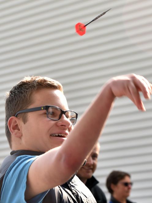 Hunter Edgecombe tries his hand at darts for the first time, during the Otago All Abilities Sports Day and Expo at Forsyth Barr Stadium yesterday. Photo: Peter McIntosh