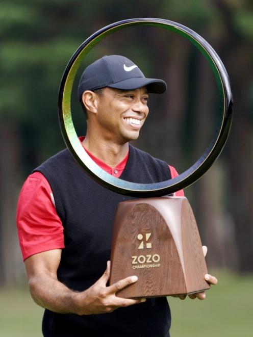 Tiger Woods celebrates with the trophy after winning the Zozo Championship. Photo: Kyodo/via...