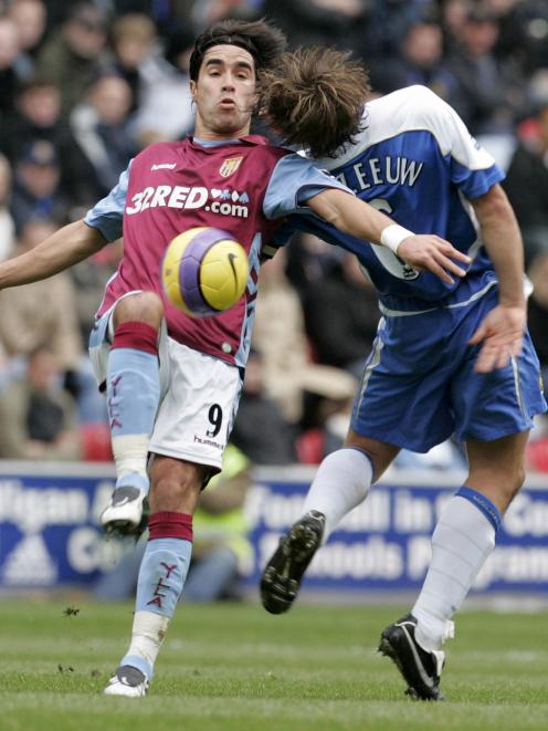 Aston Villa's Juan Pablo Angel is challenged by Wigan Athletic's Arjan De Zeeuw for the ball in this file photo from November 2006. Photo: Reuters
