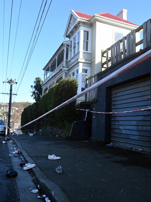 Litter and shoes lie on the footpath outside a Dunedin flat where one person died and two were...