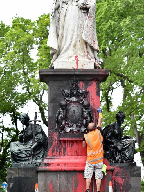 Roger Knauf, of Graffiti Doctor, starts the job of removing red paint from the historic Queen...