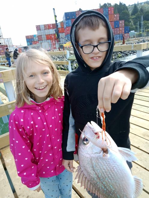 Sienna and Liam Dalley, of Townsville, Australia, celebrate a rare catch of snapper at the new...
