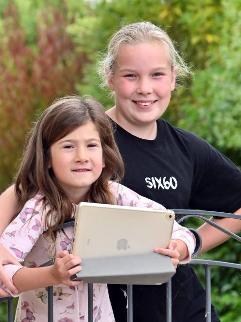 Charlotte (6) and Brooke Reddington (10) are finding there are pros and cons in doing school work...