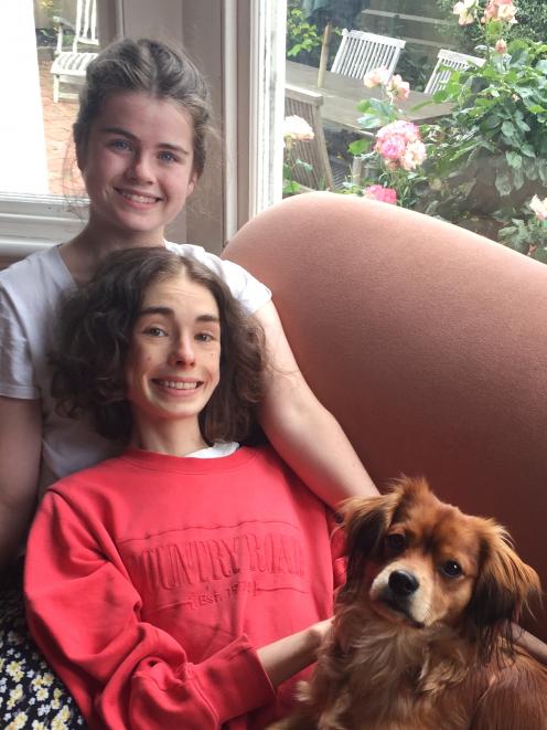 Hannah Hardiman (15) and sister Millie Hardiman (18), whose hopefully life-saving trip to the United States has been delayed, with puppy Benji. Photo: Supplied