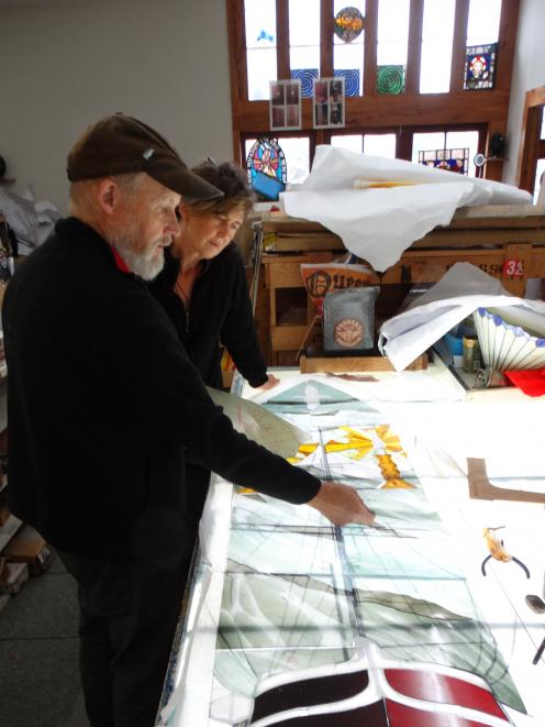 Stained glass specialist Peter Mackenzie (left) and artist Jenna Packer discuss the placement of...