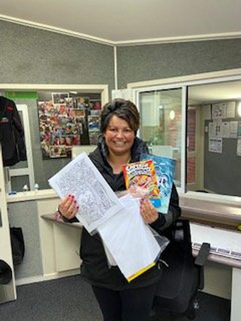 Brockville School principal Tania McDonald holds one of the education packs that staff have been creating for pupils over the past two days, so they can continue their learning while in lockdown. Photo: Supplied