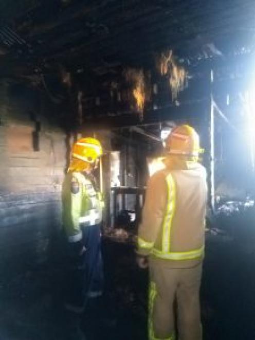 Firefighters inspect the smoke and fire-damaged home. Photo: Supplied