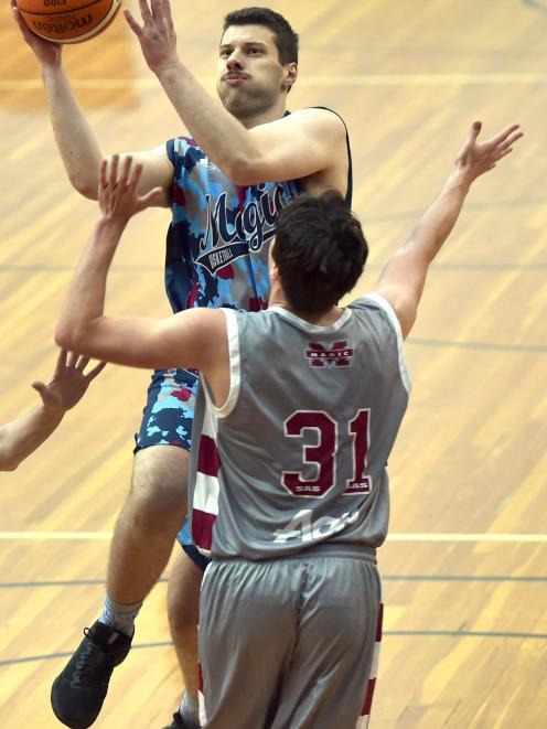 Magic Lions player James Scobie pops a shot over the head of Magic A player Joe Ahie during a...