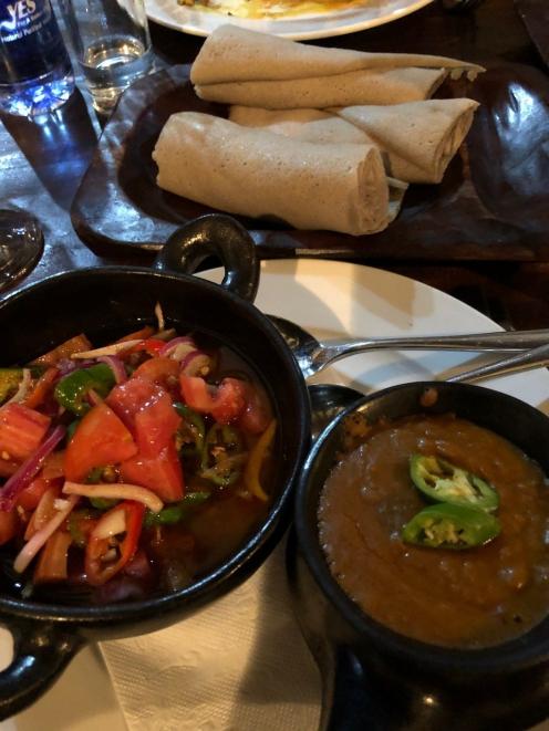 A lentil stew, tomato and red onion salad and rolled injera.