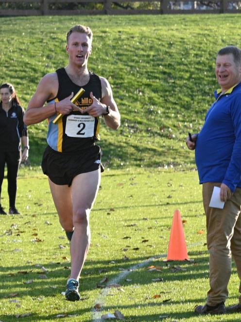 Hill City-University senior men’s final relay runner Russell Green crosses the line 
...