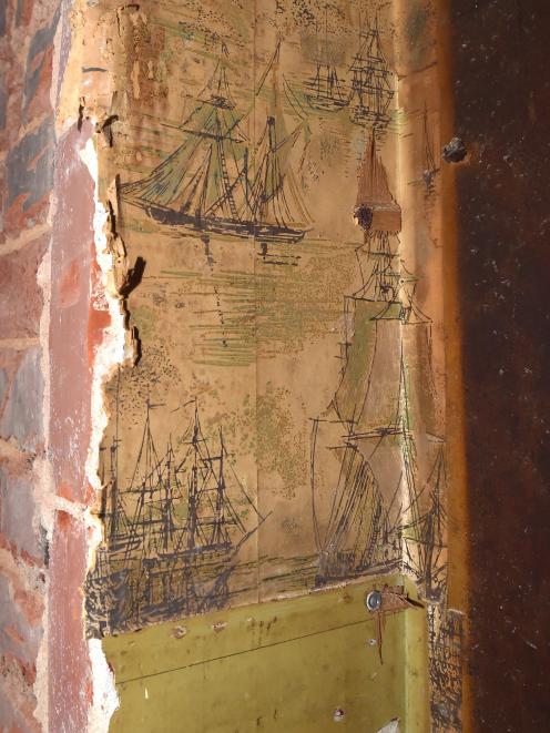 Old wallpaper inside the hole in the wall shows drawings of ships. PHOTO: GREGOR RICHARDSON