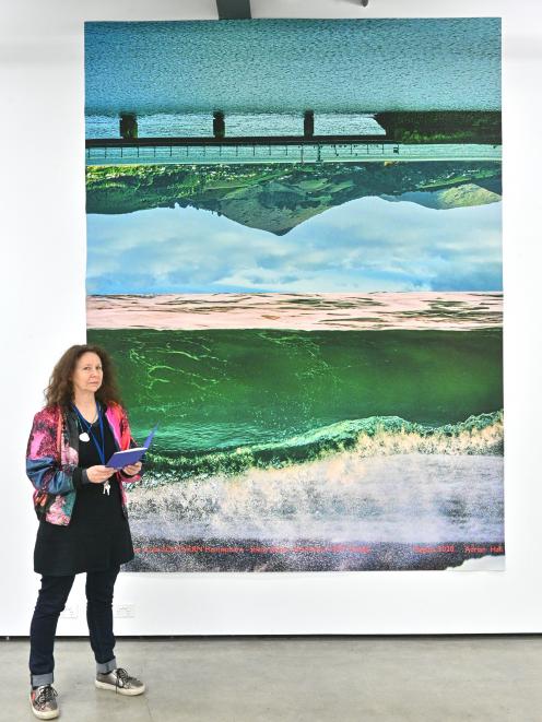 One of the co-ordinators of a Dunedin symposium, Pam McKinlay, stands in front of a photographic...