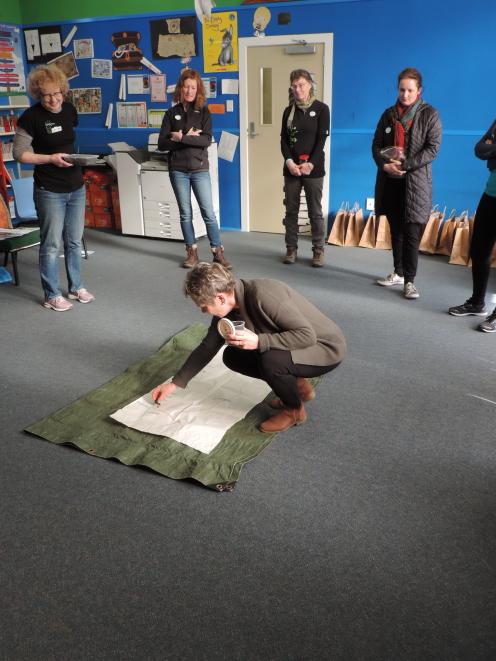 Weston School teacher Jenny Kitchin places soil from her home garden on to a map of Otago during...