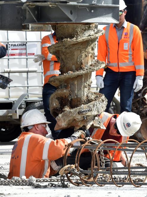 Workers drill the first pile.