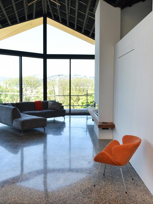 The polished concrete floor has stones gathered from local beaches. A space-saving swivel door is...
