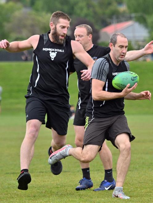 Drunken Devils player Nic Jepson runs with the ball supported by team-mate Kurt Chisholm at...