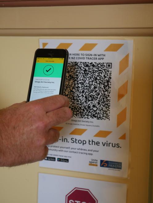 A member of the public scans a QR code using the NZ Covid Tracer app.PHOTO: JESSICA WILSON