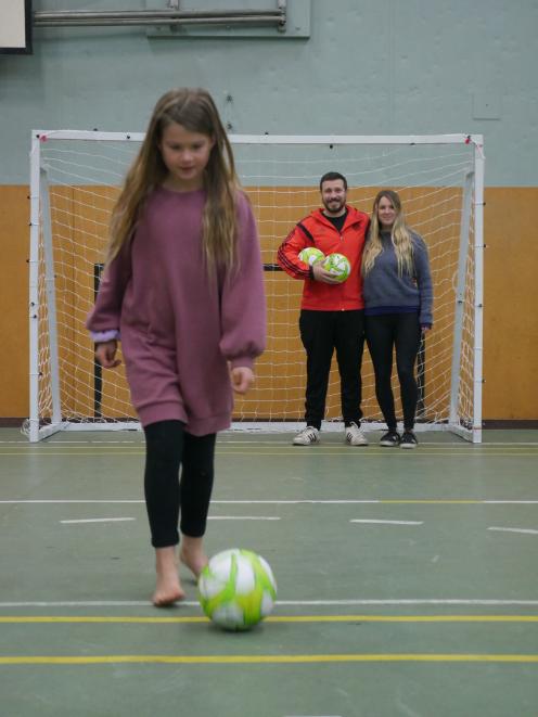 Sienna Sainsbury (8) kicks a ball while her parents and Dunedin Futsal Academy founders Maxi...