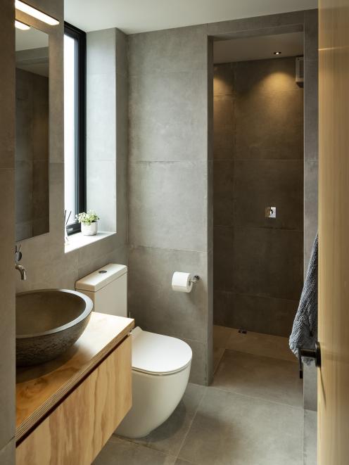 The wet-room style of the compact bathroom is reminiscent of a Japanese spa, with floor-to...