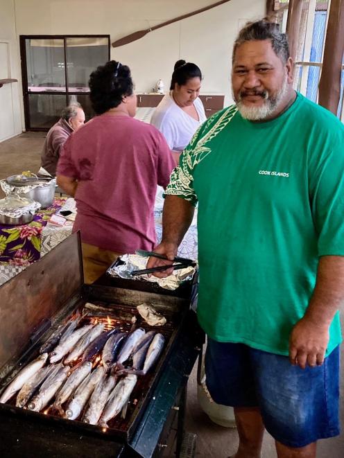 Barbecuing flying fish for breakfast at Aitutaki morning market. Photo: Supplied
