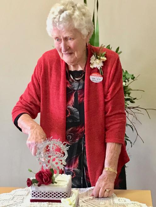 Velda Hodgson (88), a member of the Fairfield Garden Club for 38 years, cuts the cake at the club...