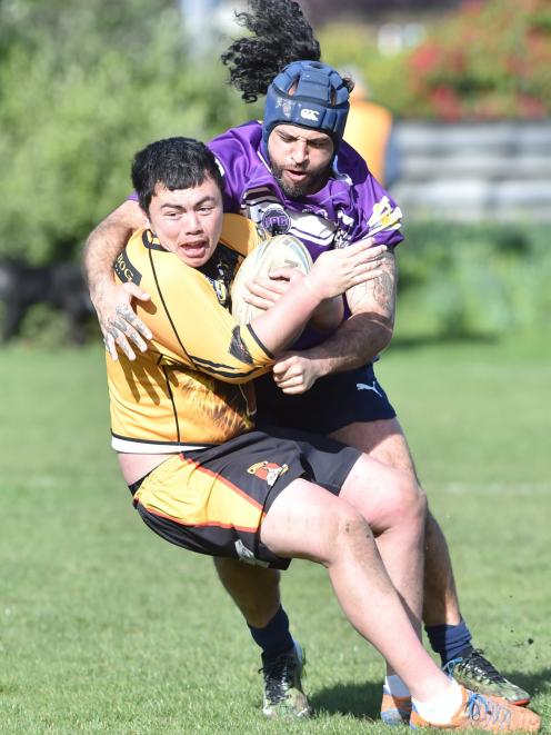 Kia Toa Tigers player Aiden Muraahi tries to escape the clutches of South Pacific Raiders...