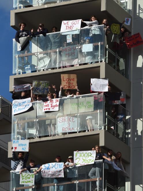 Showing their support for the community from the safety of their balcony are residents of...