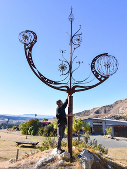 Artist Raymond Herber with one of his sculptures at the Iron Ridge Quarry Sculpture Park.PHOTO:...