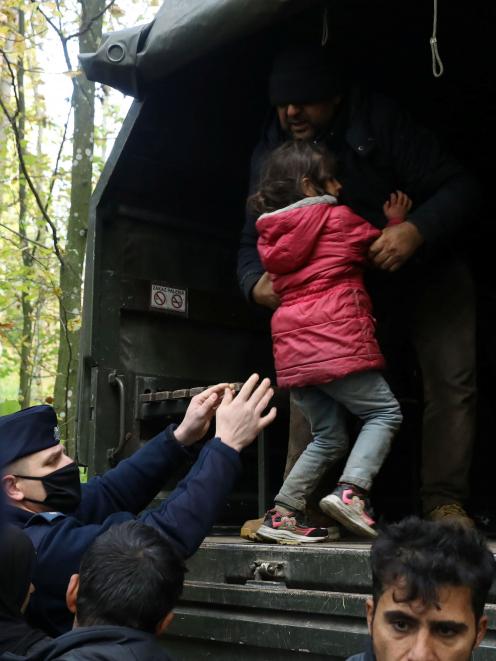 Iraqi migrants are put on a military truck after being caught by border guards and police...