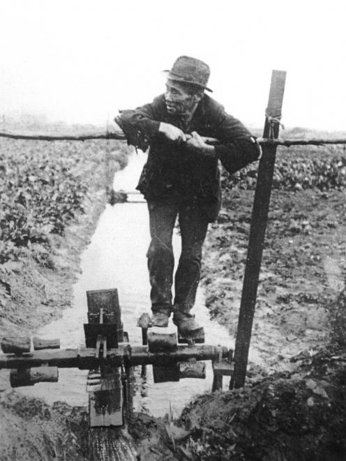 A Chinese market gardener works a water wheel on his plot of rented land on the site of what is...