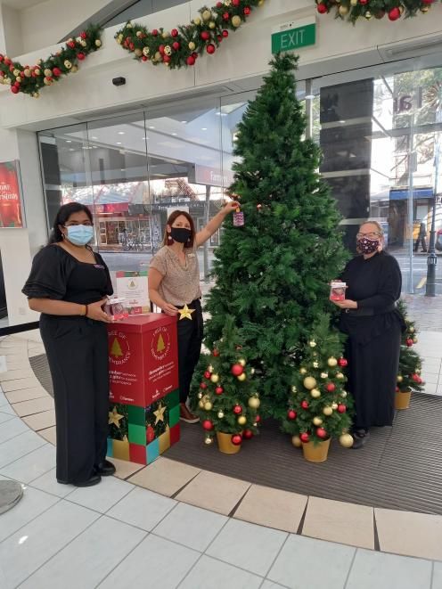 Preparing the Tree of Remembrance for shoppers at the Farmers Dunedin store are (from left)...