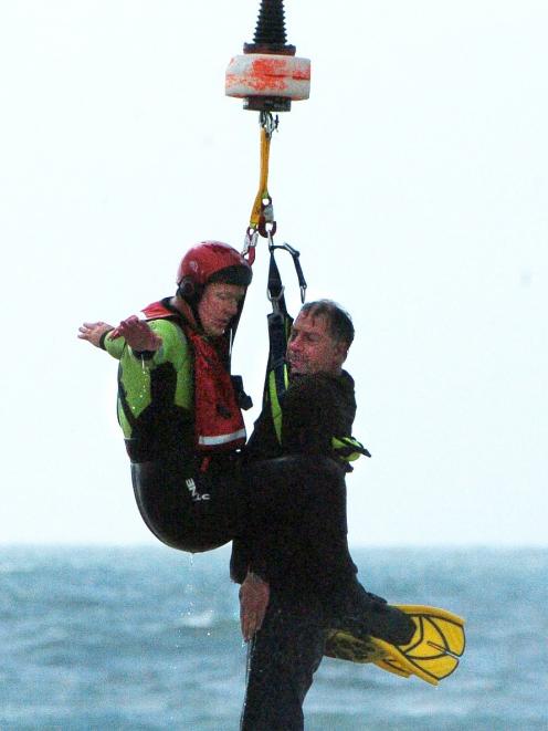Greg Clark is rescued by Dunedin Marine Search and Rescue squad member Paul Sharp from the surf...