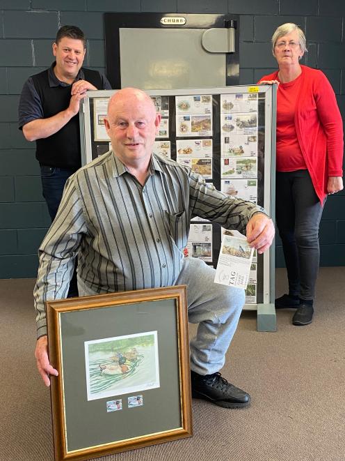 Otago Philatelic and Postcard Society member Graham Pelvin (centre) showcases a print of one of...