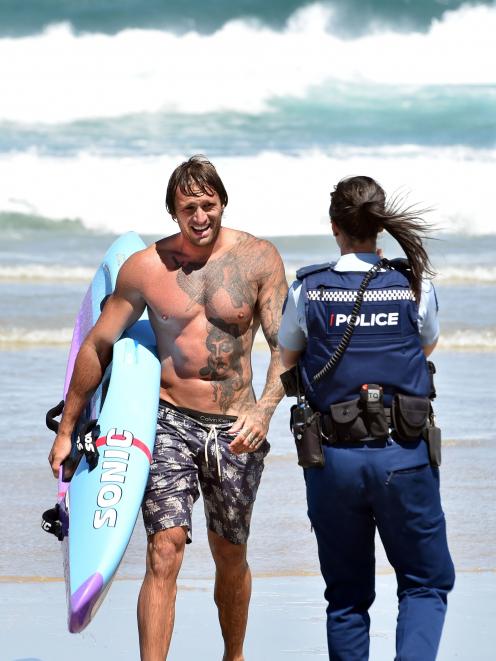 St Kilda surf life-saver Rob Ratten talks to a policewoman after he rescued three men from a rip...
