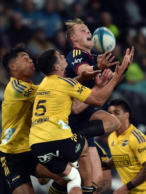 Highlanders wing Sam Gilbert takes a high ball as he is surrounded by Hurricanes players ...