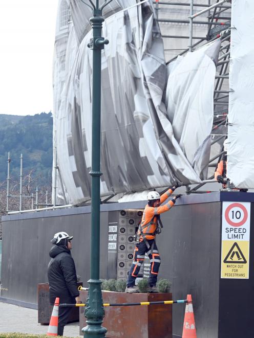 Workmen battle to secure Dunedin Railway Station’s covering in strong winds yesterday. PHOTO:...