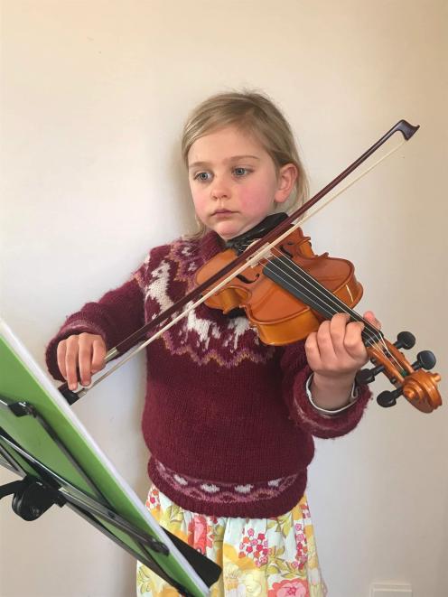 Six year-old violinist Charis Lehr, a pupil of Ella George, practices at home ahead of Saturday’s...