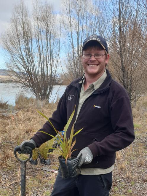 Otago Fish & Game officer Ben Sowry plants native trees at the Bendigo Wilderness Reserve. PHOTO:...