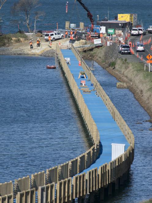 The last section of a 610m boardwalk at Blanket Bay in Otago Harbour is lifted into place...