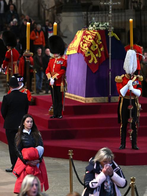 Members of the public pay their respects as they pass the coffin of Queen Elizabeth II, Lying in...