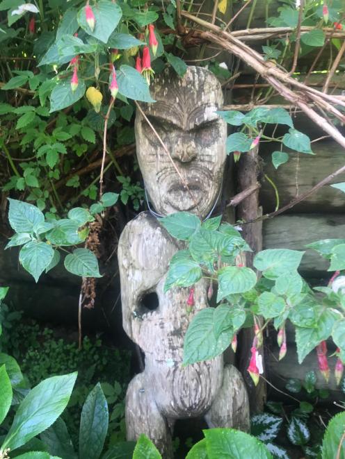 A Maori figure stands guard in the garden.