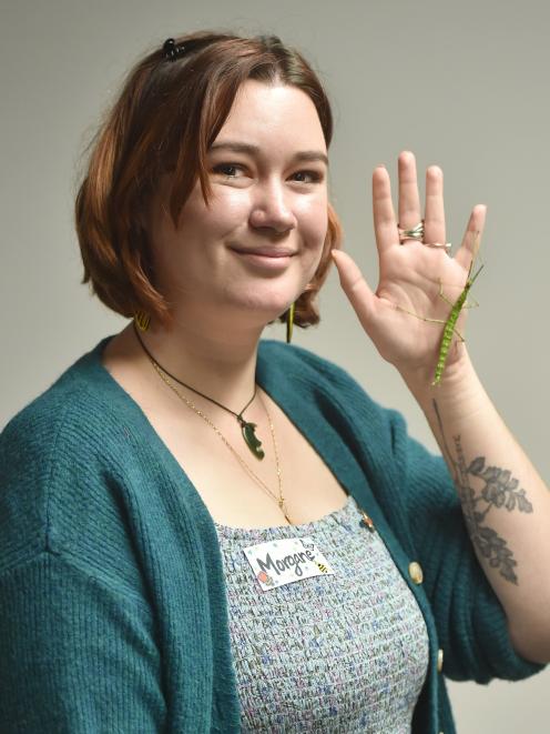 Entomological Society of New Zealand member Morgane Merien displays a stick insect next to her...