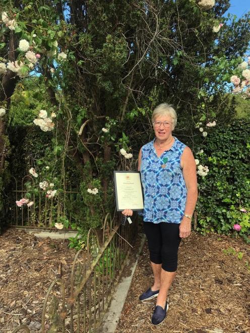 Holding her certificate and wearing the medal awarded for her work with old roses is Fran Rawling...