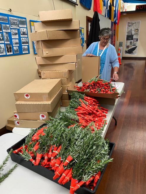Dunedin RSA and RSA Welfare Trust administrator Sally Turner packs posies into boxes, ready to be...