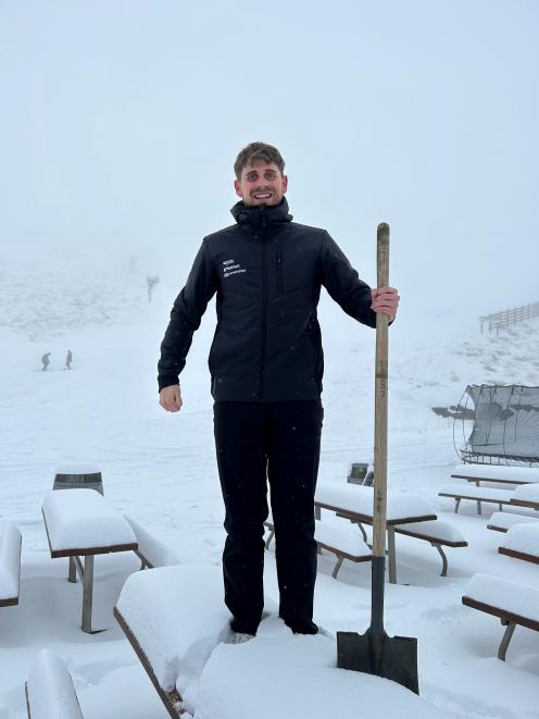 NZSki’s Henry Mason takes a break from shovelling to show off the amount of snow that settled at...