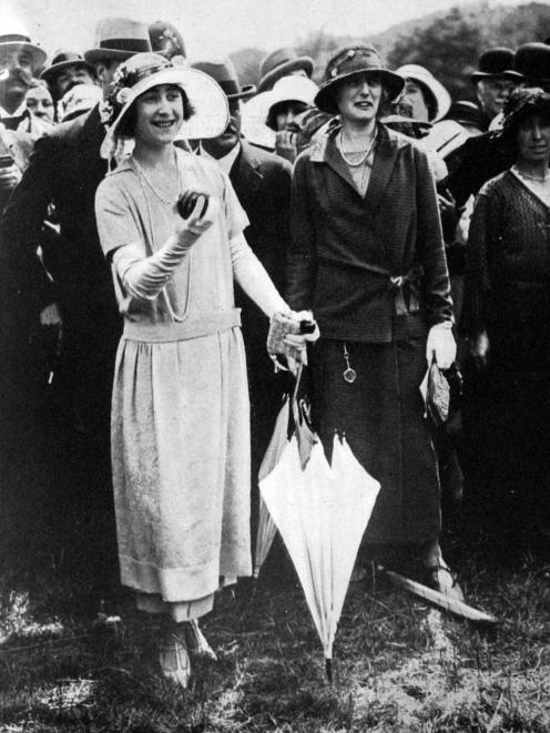Elizabeth, Duchess of York (wife of future King George VI) has a go on the coconut shie at a...