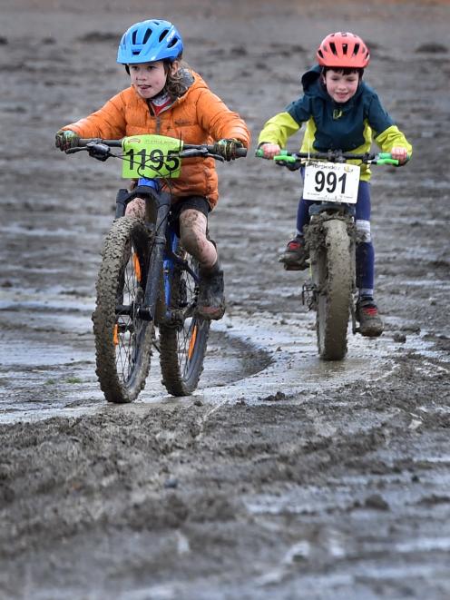 Luka Dunstan, 5,  and John Garvey,  6, pedal through the mud in the Cyclo-groms round at the 2023...