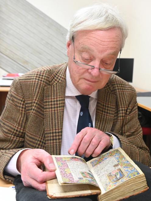 Dr Christopher de Hamel peruses medieval manuscripts at Dunedin City Library during his visit to...