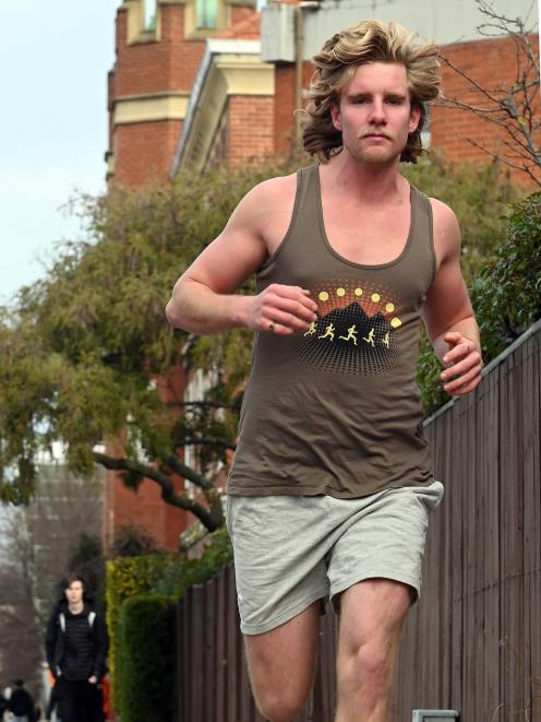 University of Otago geography student Christian Griffin trains barefoot in Castle St, for the...
