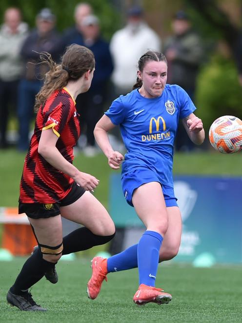 Southern United wing-back Freya Partridge-Moore taps the ball on under pressure from Ellerslie...